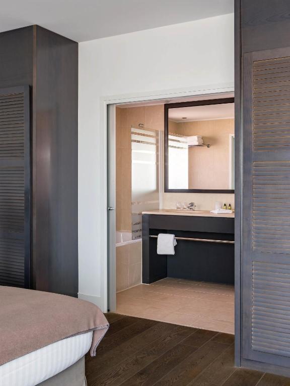 a bedroom with a bed and a bathroom with a sink at New Hotel of Marseille - Vieux Port in Marseille