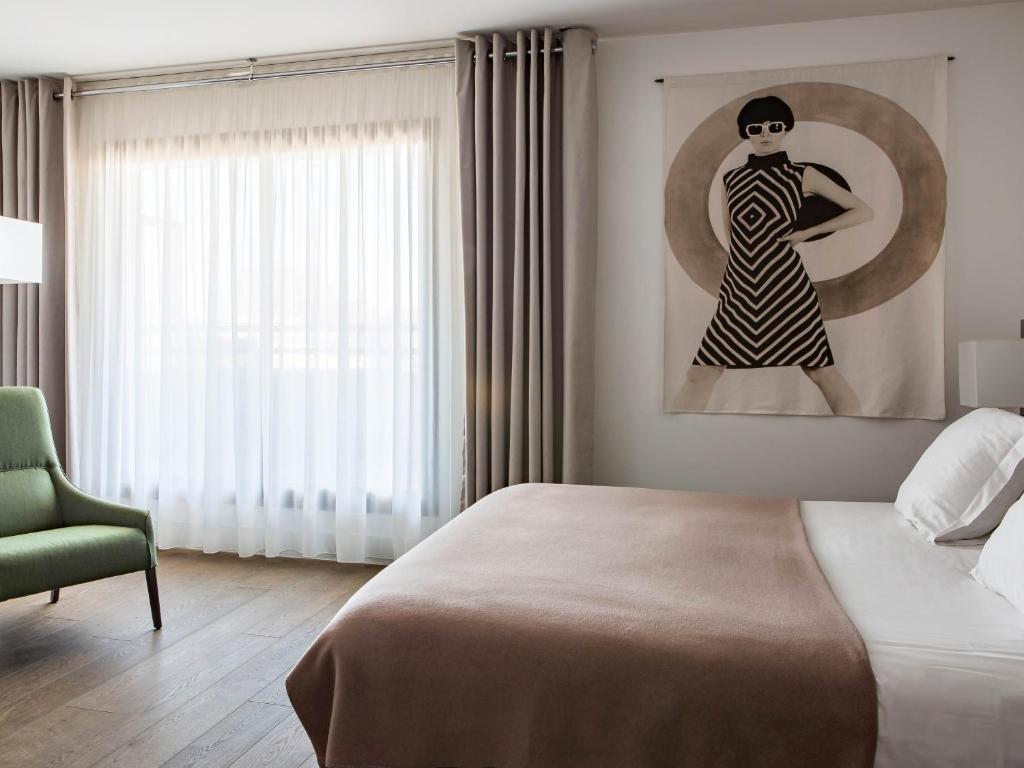 a bedroom with a bed and a painting of a woman at New Hotel of Marseille - Vieux Port in Marseille