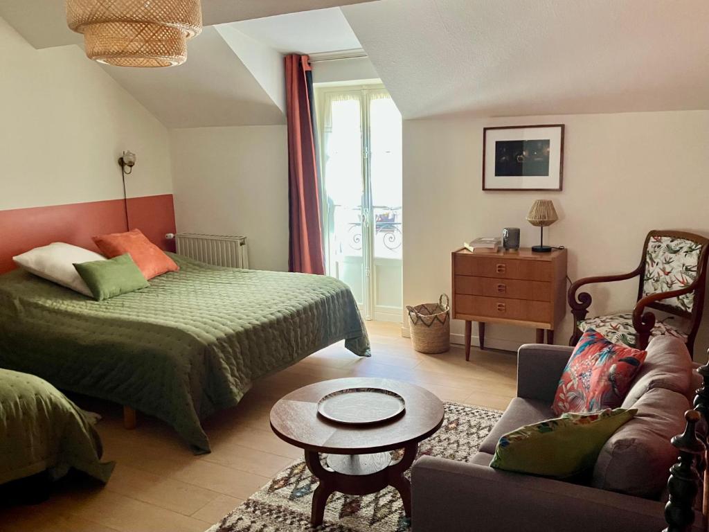 a bedroom with a bed and a couch and a table at La Treille Muscate in Tannay