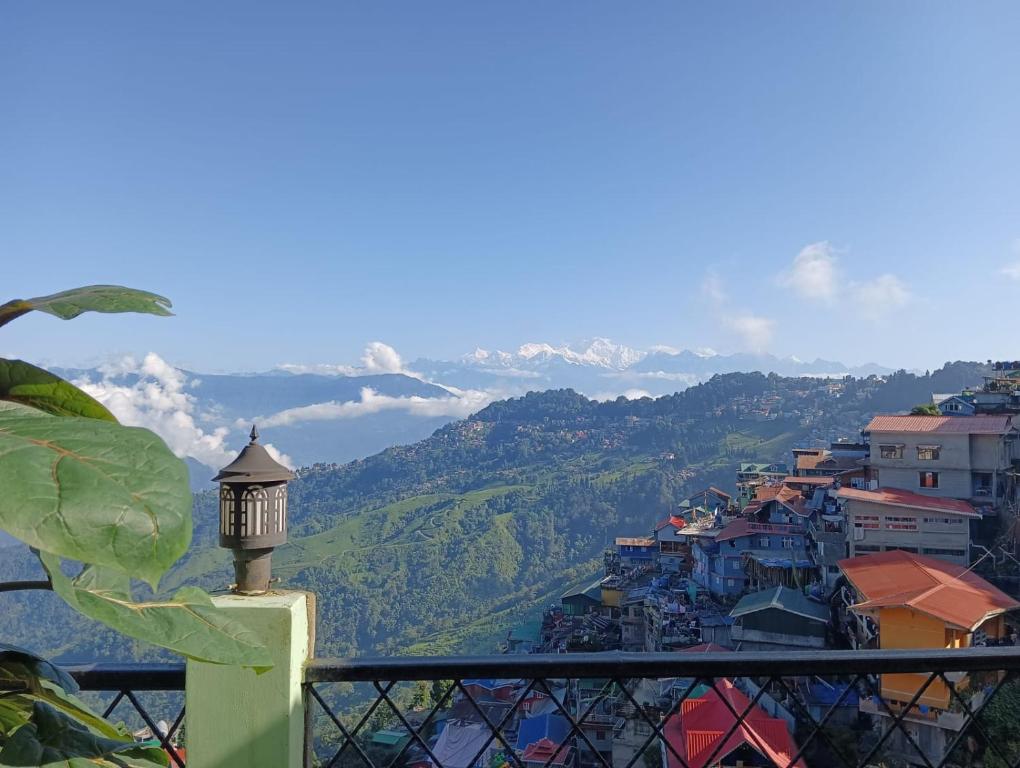 a street light on a balcony with a view of a city at Dew Drops Guest House in Darjeeling