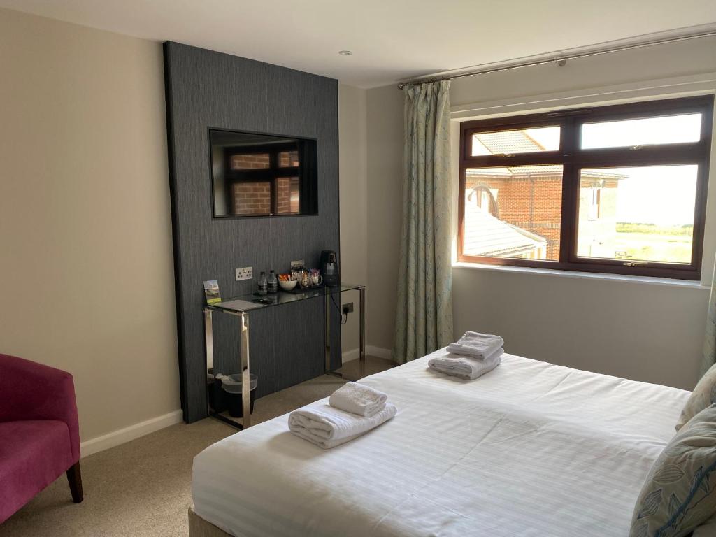 Habitación de hotel con 2 camas y ventana en Hunley Golf Club en Saltburn-by-the-Sea