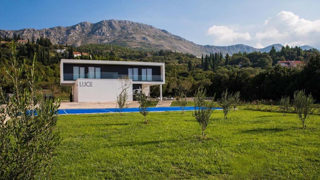 ein Haus inmitten eines Feldes mit Pool in der Unterkunft Stylish villa near Dubrovnik with a swimming pool in Mlini
