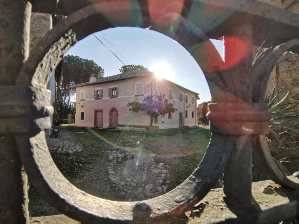 une maison vue à travers une clôture avec une fenêtre dans l'établissement Corte Signoretti - Hystorical Villa, à Canale Monterano