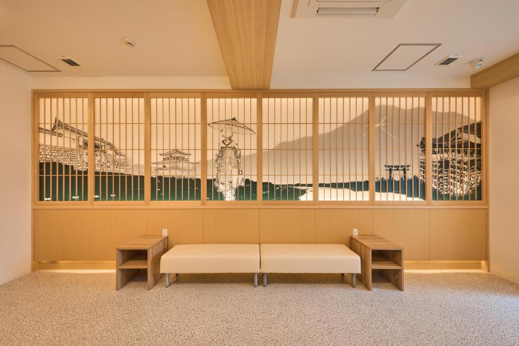 uma sala de espera com dois bancos e uma janela em 若 京都河原町ホテル Waka Kyoto Kawaramachi Hotel em Quioto