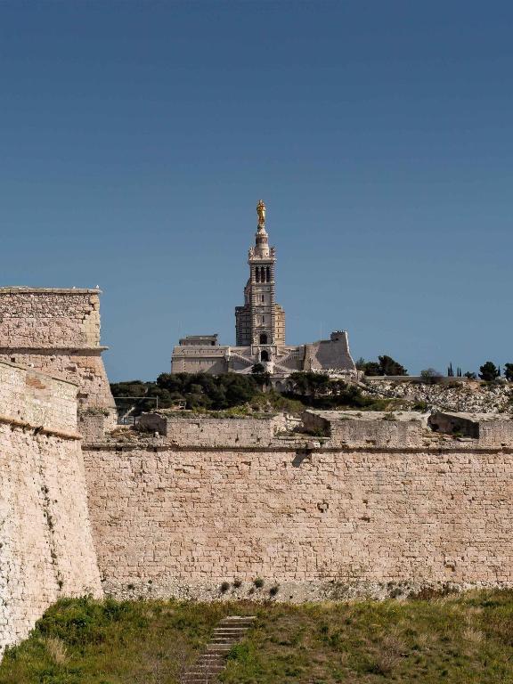 a building on top of a brick wall at New Hotel of Marseille - Vieux Port in Marseille