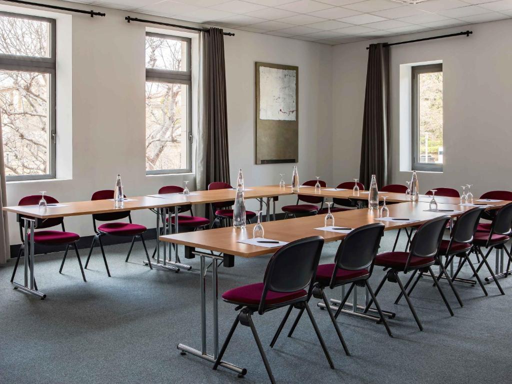 a conference room with tables and chairs and windows at New Hotel of Marseille - Vieux Port in Marseille