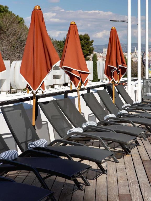 a row of chairs and umbrellas on a patio at New Hotel of Marseille - Vieux Port in Marseille