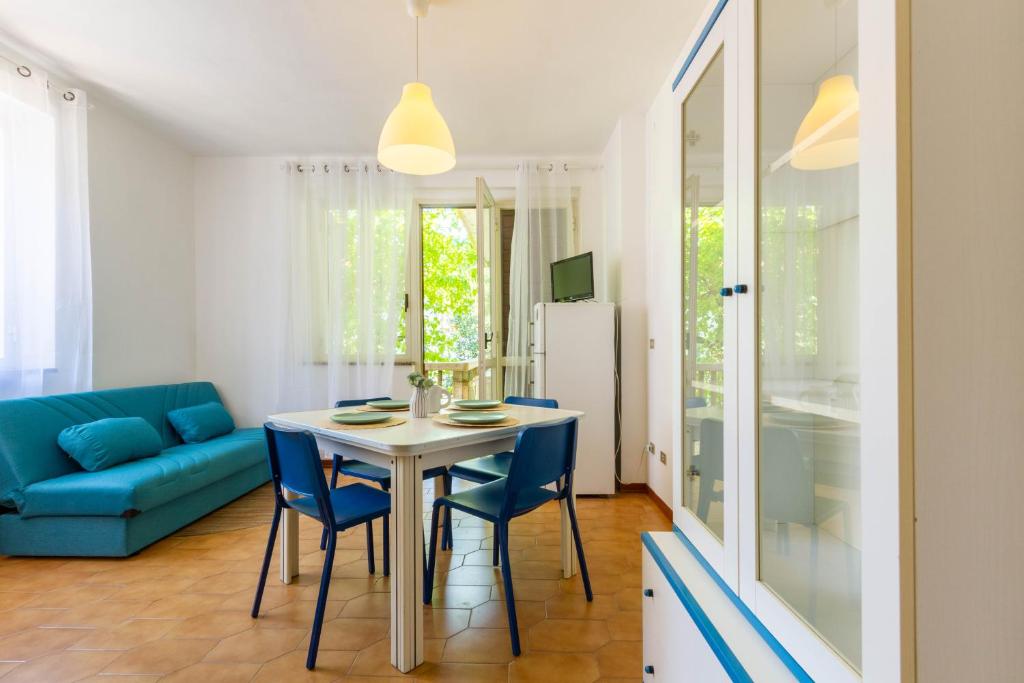 トルトレート・リドにあるAppartamento La Pinetina Trilo - MyHo Casaのキッチン、ダイニングルーム(テーブル、青い椅子付)