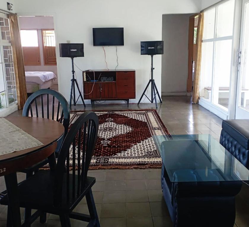 CampakaにあるSurga Dirga Resortのリビングルーム(テーブル、テレビ付)
