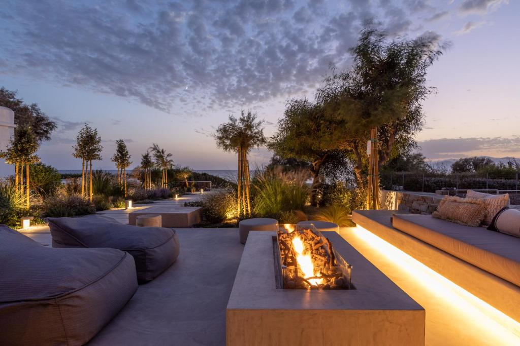 a patio with couches and a fire pit at Beachfront 3BR Villa Iremia in Naxos in Naxos Chora