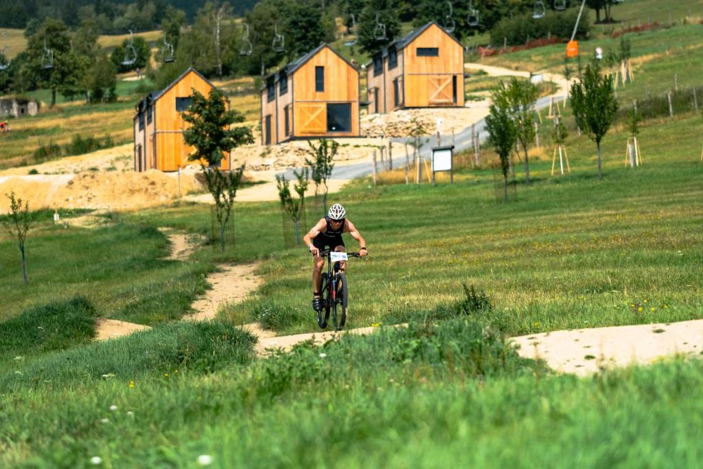 un hombre montando una bicicleta por un camino de tierra en Apartmány Trojice, en Hynčice pod Sušinou