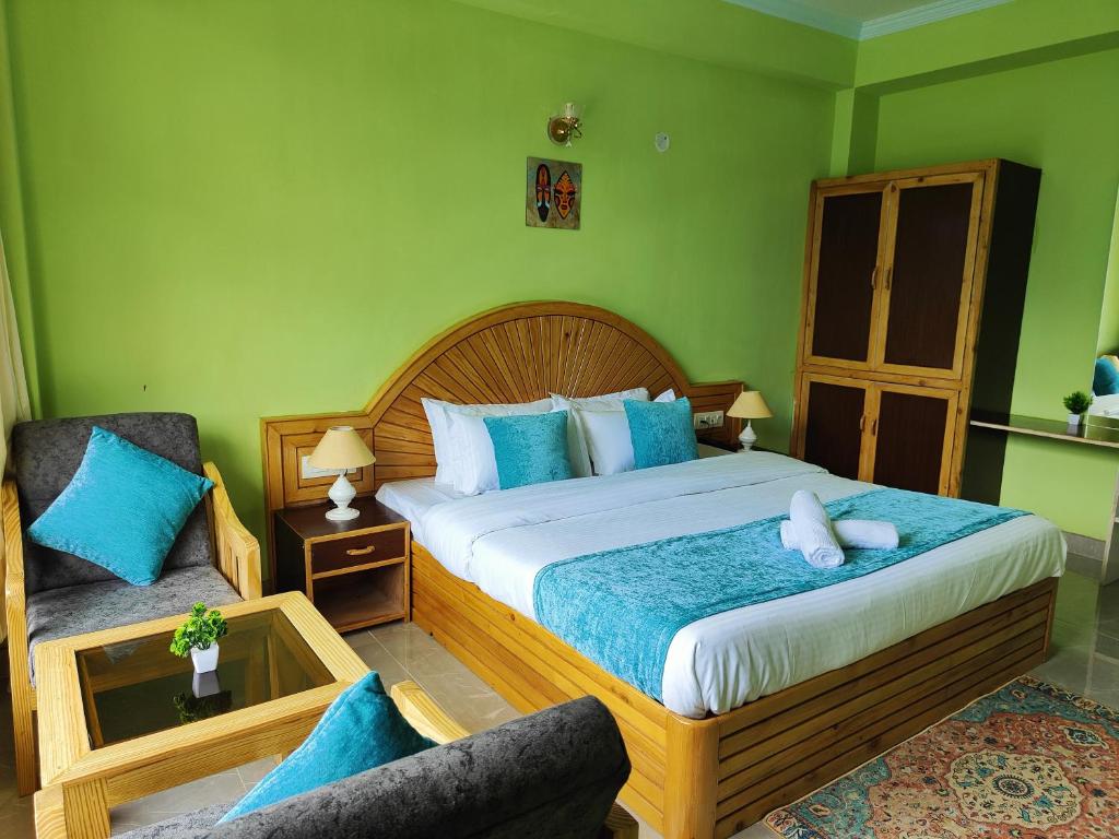 - une chambre avec un grand lit et une chaise dans l'établissement The Nush Stays, à Manali