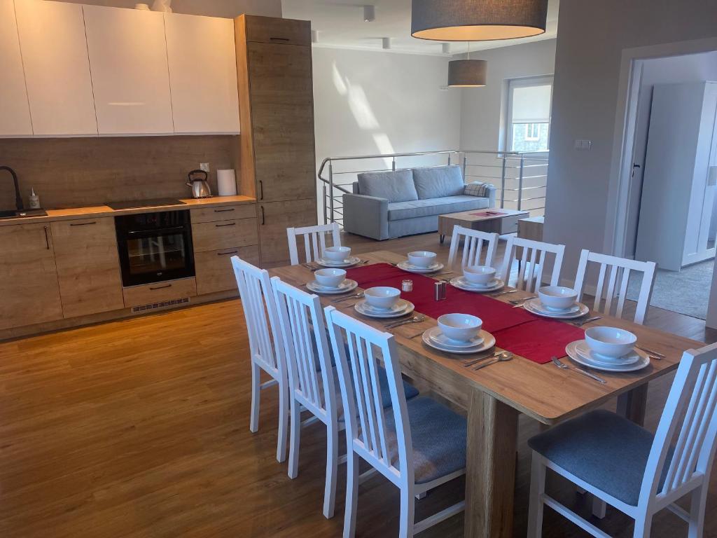 uma cozinha e sala de jantar com uma mesa de madeira e cadeiras em Apartament Daleszyce em Daleszyce