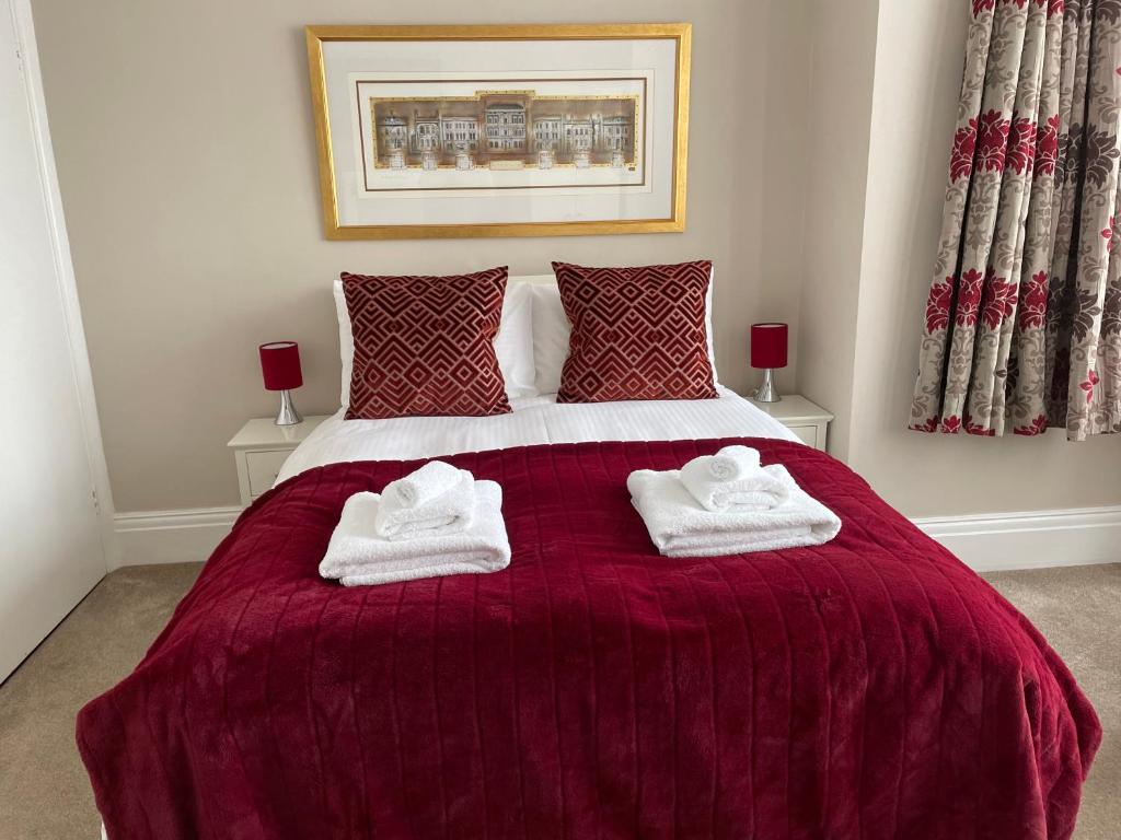 a bedroom with a bed with two towels on it at The Sandrock in Clacton-on-Sea