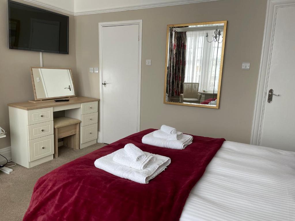a bedroom with two towels sitting on a bed at The Sandrock in Clacton-on-Sea