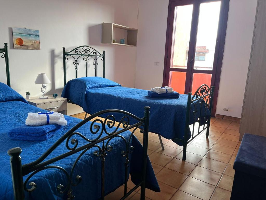 sypialnia z 2 łóżkami i niebieską pościelą w obiekcie Caravaggio Apartment w mieście Porto Cesareo