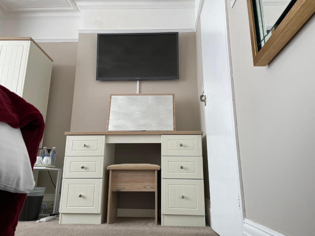 a bedroom with a desk with a tv on the wall at The Sandrock in Clacton-on-Sea