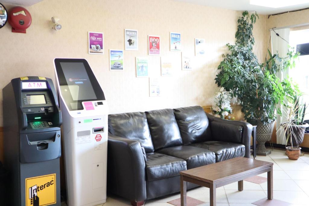 a living room with a leather couch and a atm machine at Destination Family Hotel in Whitehorse