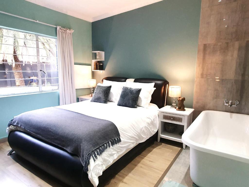 a bedroom with a large bed and a bath tub at Dream Sandton Villa 'Maison de Ky' Swimming pool tennis court free WI-FI in Johannesburg