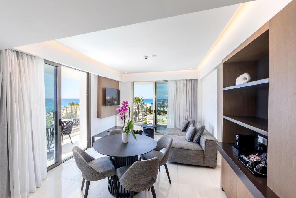 a living room with a table and chairs and a couch at Pavlo Napa Beach Hotel in Ayia Napa