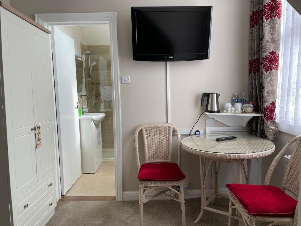 a room with a table and chairs and a television on the wall at The Sandrock in Clacton-on-Sea