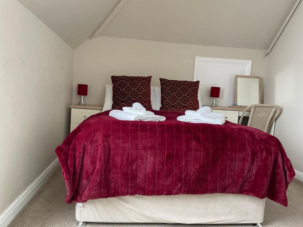 a bedroom with a large bed with a red blanket at The Sandrock in Clacton-on-Sea