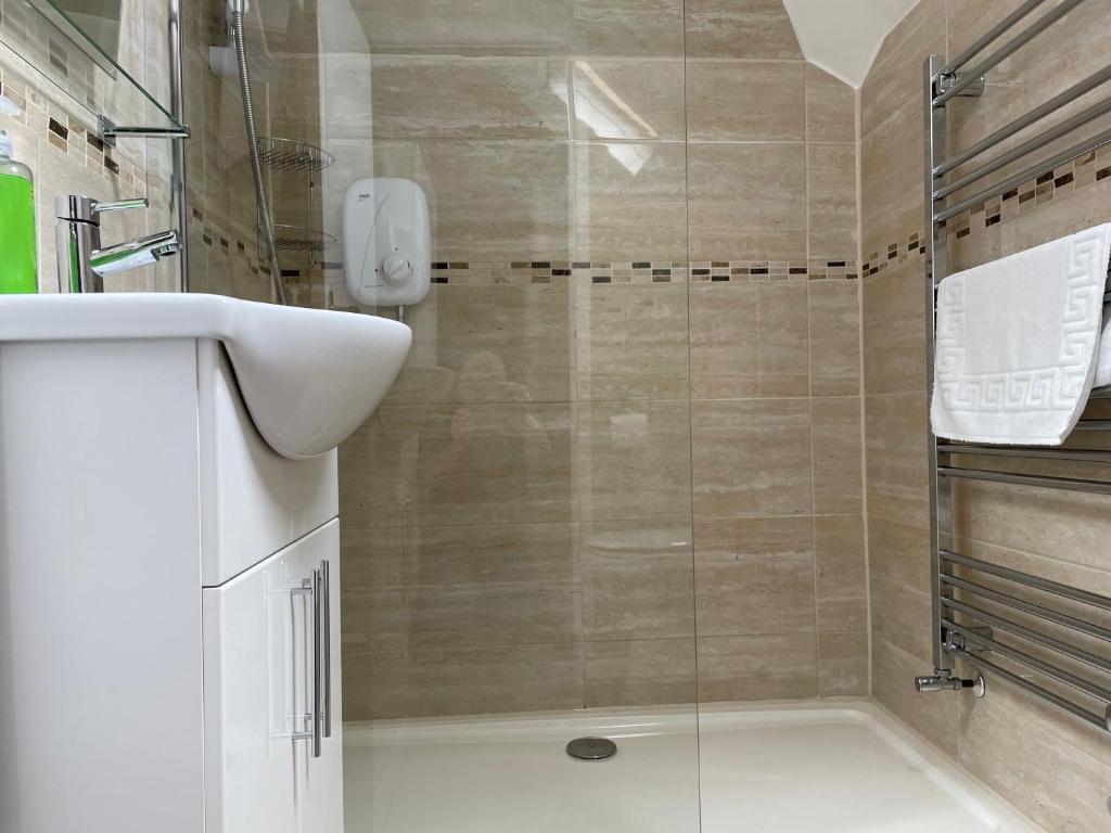 a bathroom with a shower with a glass door at The Sandrock in Clacton-on-Sea