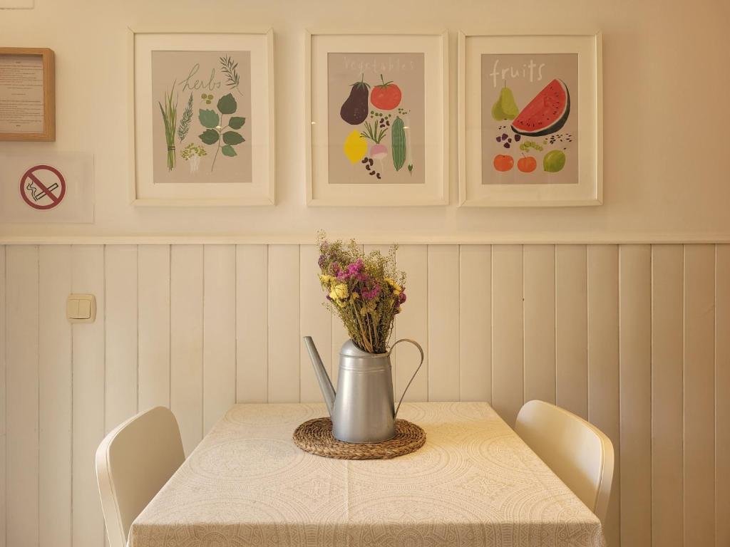 a table with a vase with flowers on it at "COZY LOFT", TERRACE, PARKING and SWIMMING POOL in Málaga