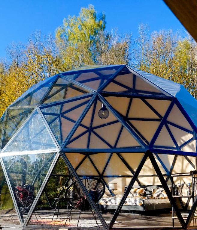 a glass dome with a table and chairs in it at Glamping dome tent BUUDA in Salacgrīva