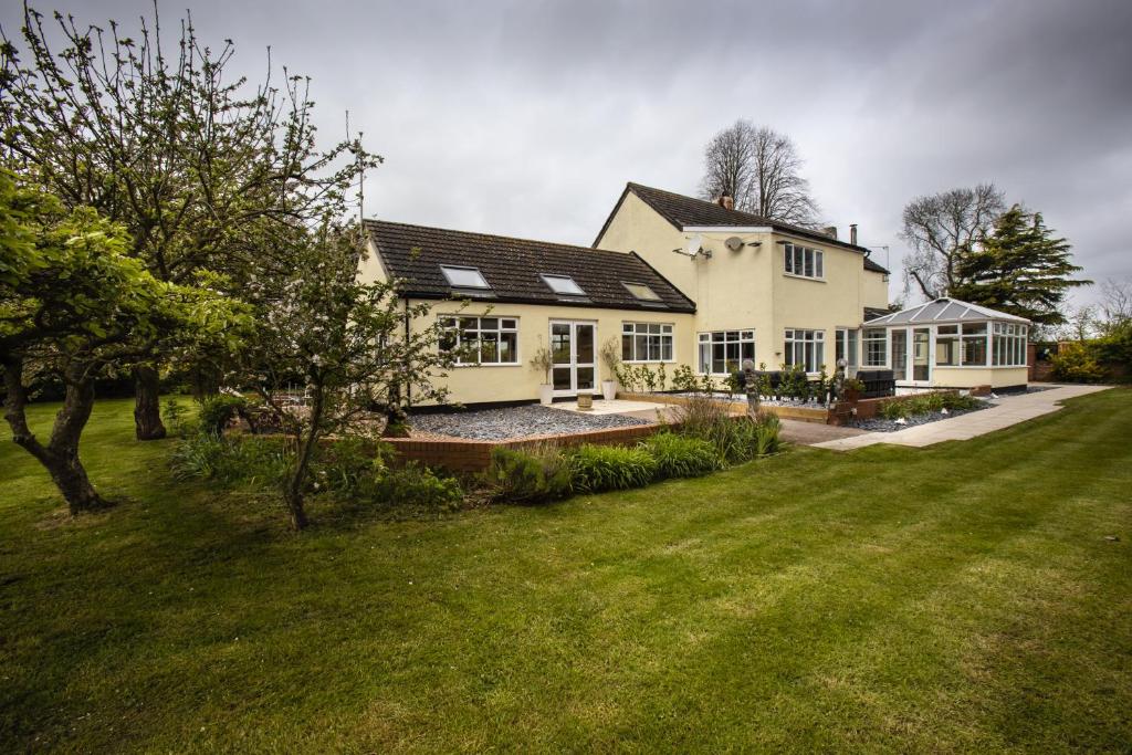 a large white house with a grass yard at The Willows in Laceby