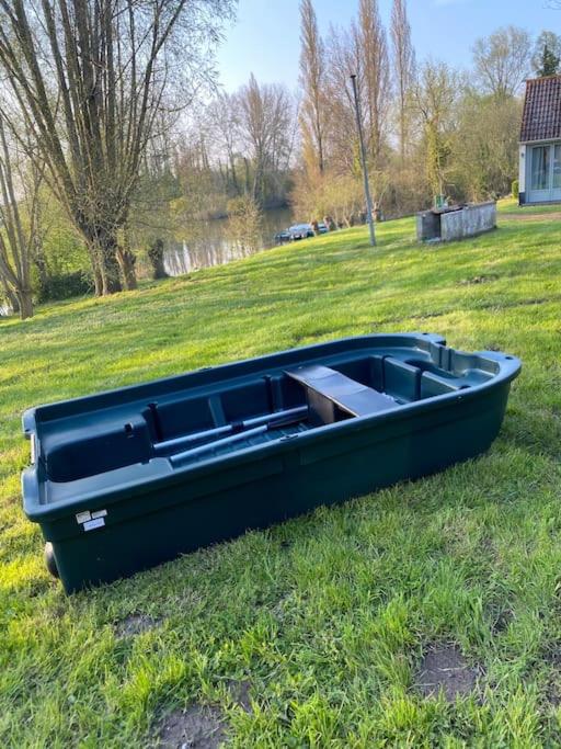 a black boat sitting on the grass in a field at Le Nid du Cygne in Houlle
