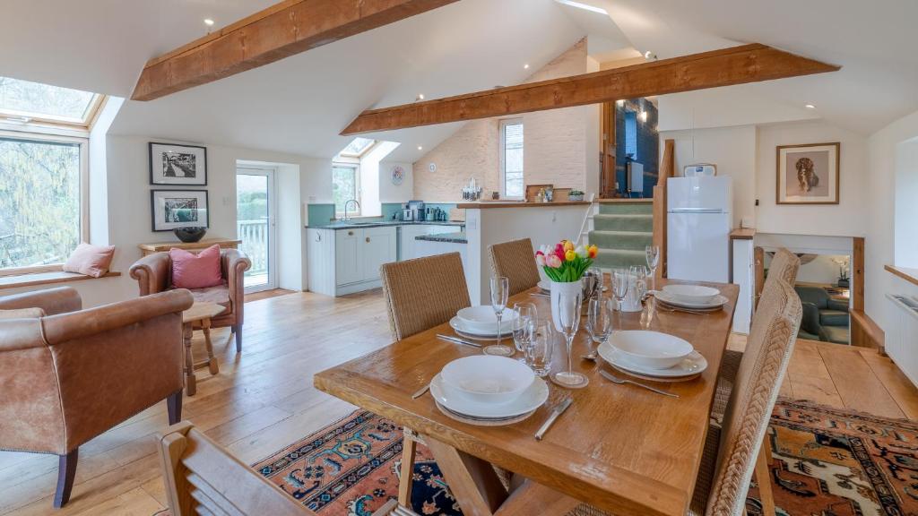 a dining room and living room with a wooden table at Wynyard Mill in Malmesbury
