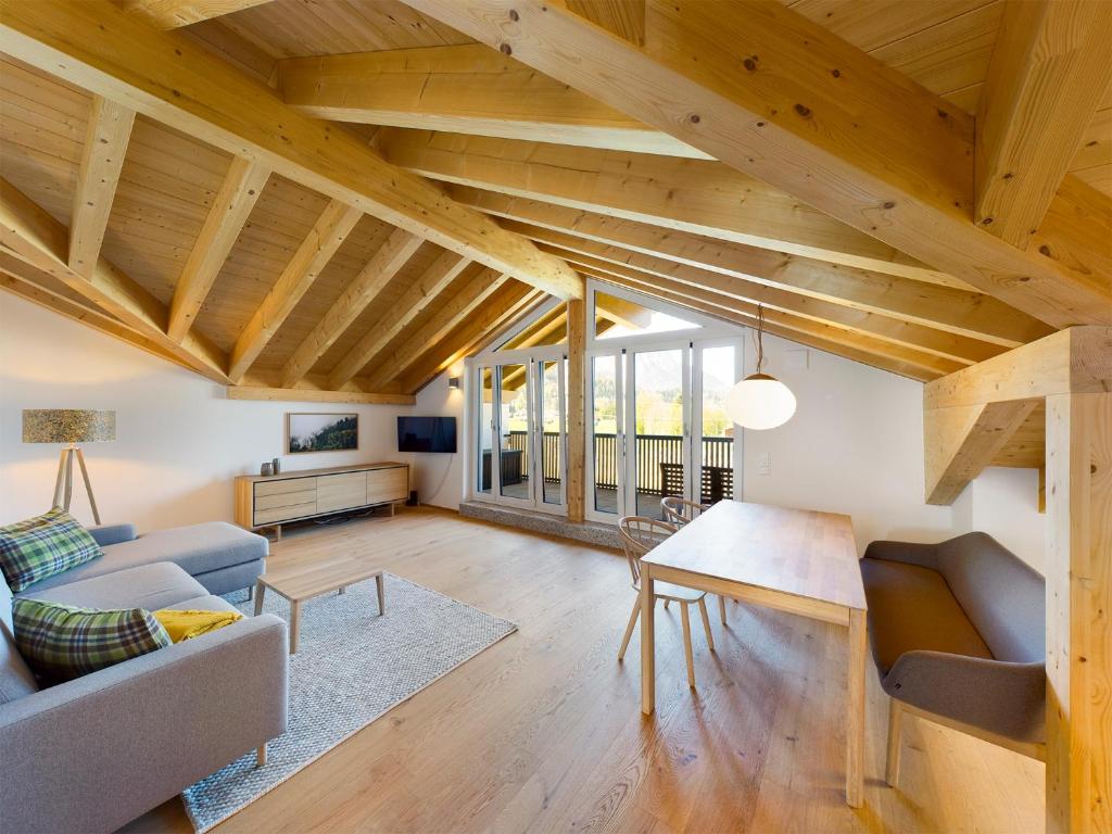 uma sala de estar com tectos em madeira e uma mesa em Gipfelkreuz mit Sauna em Garmisch-Partenkirchen