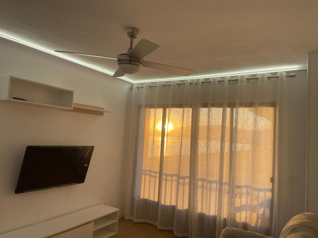 ein Wohnzimmer mit einem Deckenventilator und einem Fenster in der Unterkunft Torrenueva con vistas al mar in Torrenueva