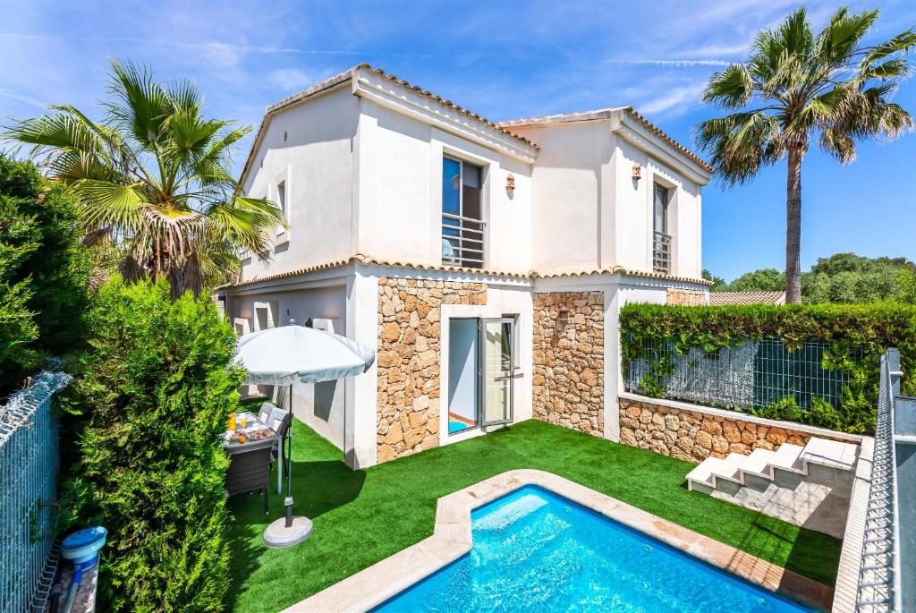a villa with a swimming pool in front of a house at Bahamas 2 in Son Serra de Marina