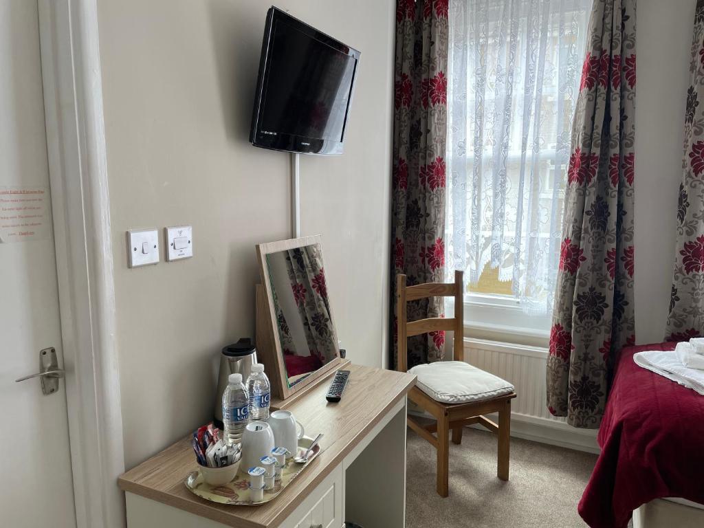 a room with a desk with a television and a bed at The Sandrock in Clacton-on-Sea