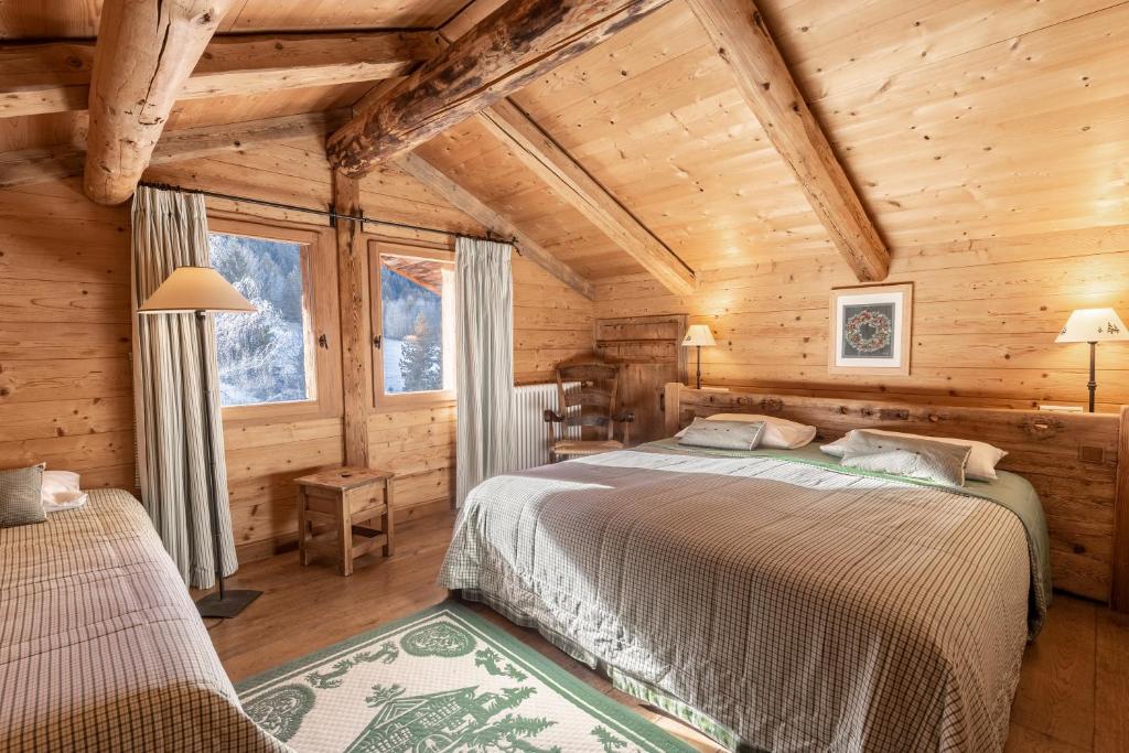 ein Schlafzimmer mit einem Bett in einem Blockhaus in der Unterkunft La Ferme du Var in La Clusaz
