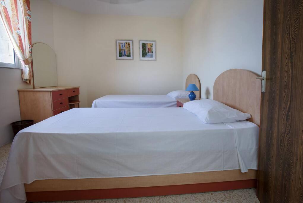 um quarto com 2 camas e lençóis brancos em Standard 1 bedroom Balluta Bay (5) em Sliema