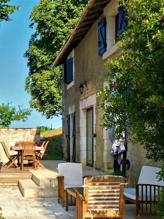 a patio with chairs and a table and a building at Maison d hôtes Casa Sana in Pillac