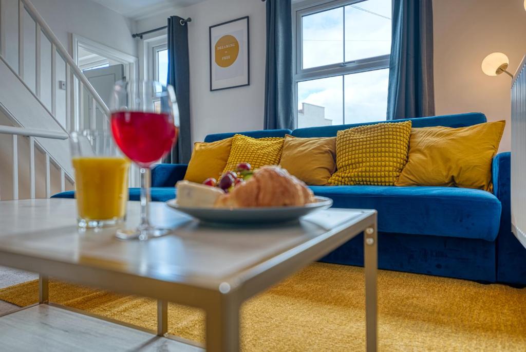 a living room with a blue couch and a table with a glass of wine at Buckwell Heights - 2 Bedroom Free Parking Wifi Sky TV in Wellingborough