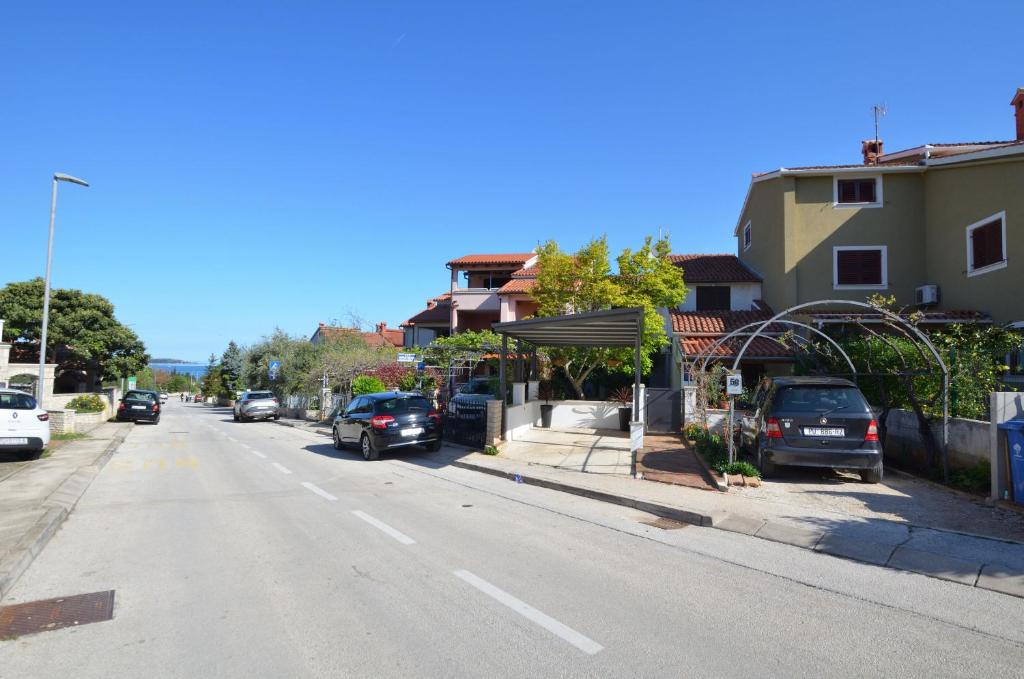 a street with cars parked on the side of the road at Apartments Maja in Štinjan
