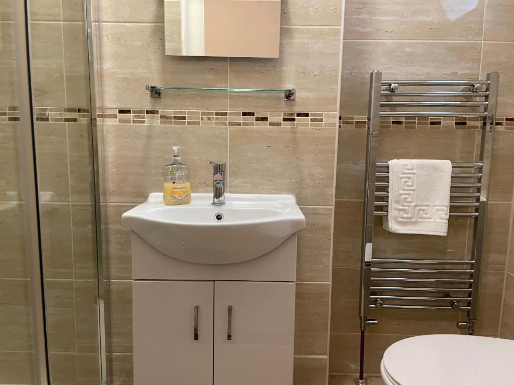 a bathroom with a white sink and a shower at The Sandrock in Clacton-on-Sea