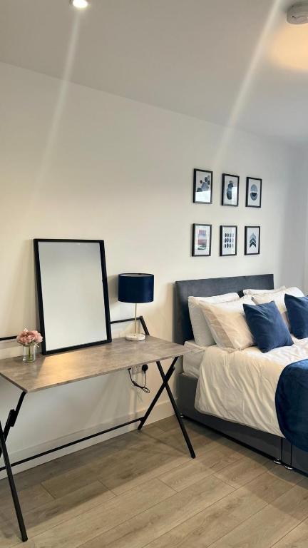 Schlafzimmer mit einem Bett und einem Tisch mit einem Whiteboard in der Unterkunft Madison Court Apartments in Hemel Hempstead