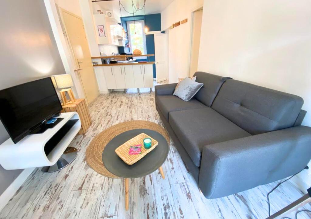 a living room with a couch and a table at La Comédie - Poitiers Centre - La Conciergerie. in Poitiers