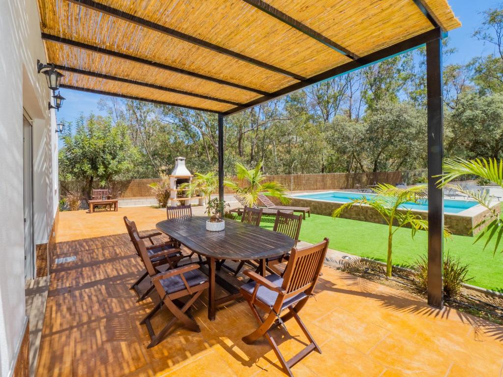 a patio with a table and chairs and a pool at Cubo's Finca Armonia in Alhaurín el Grande