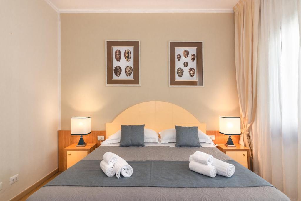 Hotel Stella D'Italia في فياريجيو: غرفة نوم بسرير وفوط بيضاء