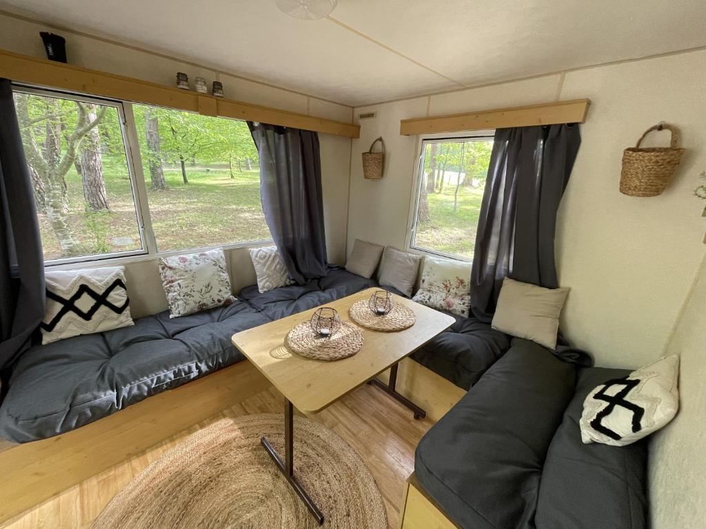 a living room with a couch and a table at Charmant Mobile Home en foret in Braize
