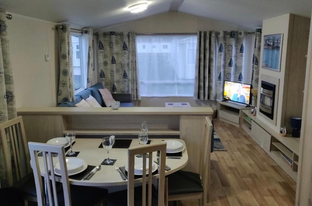 a dining room and living room with a table and chairs at The Ruby Lido Beach Prestatyn in Prestatyn