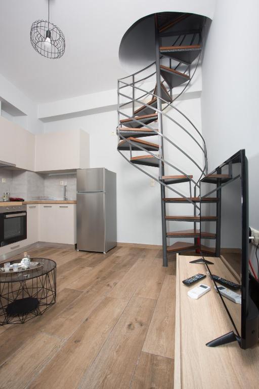 a kitchen with a spiral staircase in a room at Lux Aprt in a Graphical Village in Kerásia
