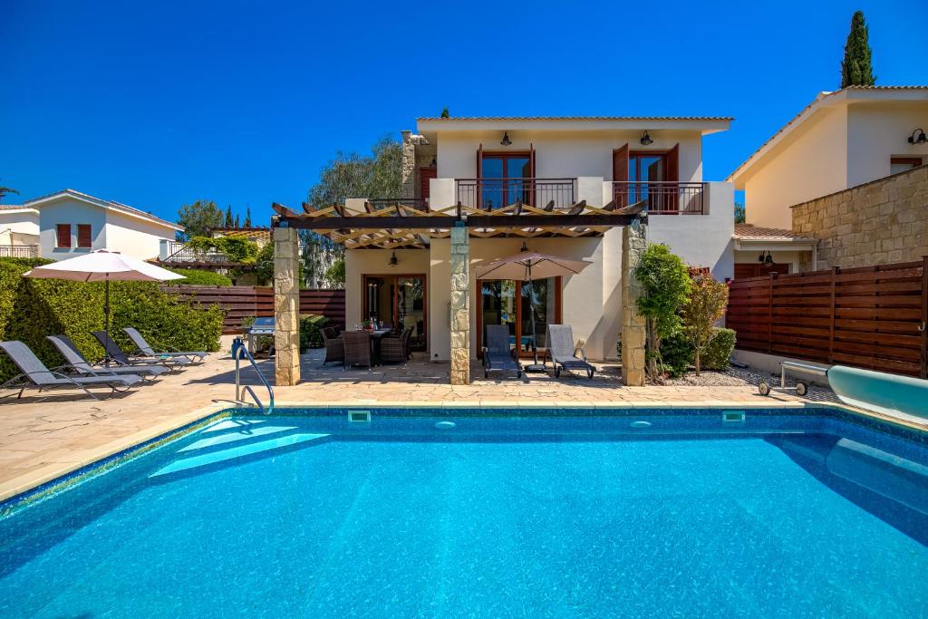 una piscina frente a una casa en 3 bedroom Villa Athina with private pool and golf views, Aphrodite Hills Resort en Kouklia